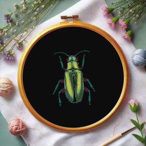 May include: A green and black beetle with red accents is embroidered on black fabric in a circular embroidery hoop.