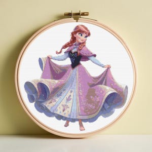 Puede incluir: Bordado de punto de cruz de una princesa en un bastidor. La princesa tiene el pelo rojo y lleva un vestido rosa y morado con un corpiño negro. El bordado está en un bastidor de madera, ideal para decoración de pared o manualidades.
