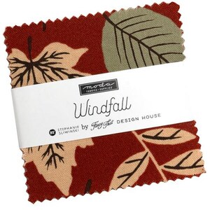 May include: A stack of square fabric swatches with pinked edges, featuring a dark red background with tan and sage green leaf patterns. A white paper band wraps around the center, printed with the text Moda Fabrics, Windfall, and Fancy That.