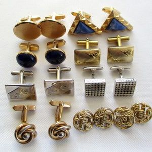 May include: A collection of 14 gold and silver cufflinks with various designs, including geometric shapes, patterned designs, and solid colors. The cufflinks are arranged in rows on a white surface.