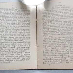 May include: An open book with aged, yellowed pages. Text is visible on both sides, with headings and numbered sections. The left page has the number 10 at the top. The right page has the number 17 at the top.
