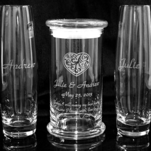 May include: A set of three glass vases with engraved names and a wedding date. The center vase is taller and has a heart design with a scroll pattern. The text reads "Julie & Andrew May 25, 2013 Today I will marry my best friend, the one I laugh with, live for, dream with, Love."
