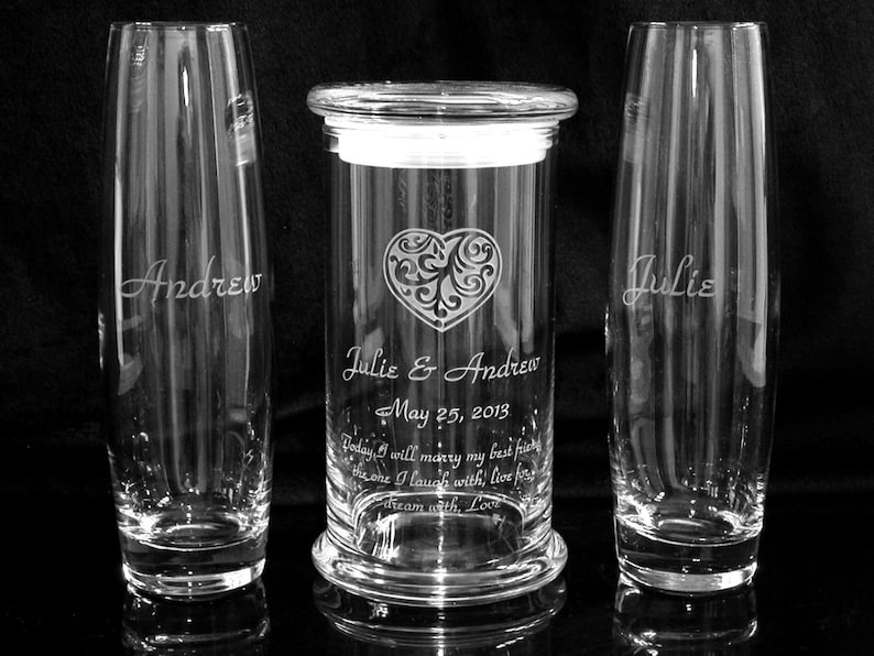 May include: A set of three glass vases with engraved names and a wedding date. The center vase is taller and has a heart design with a scroll pattern. The text reads "Julie & Andrew May 25, 2013 Today I will marry my best friend, the one I laugh with, live for, dream with, Love."