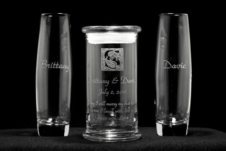 May include: Two clear glass champagne flutes with the names "Brittany" and "David" etched on them, and a clear glass cylinder vase with the names "Brittany & David" and the date "July 2, 2016" etched on it. The vase also has a quote etched on it: "Today I will marry my best friend, the one I laugh with, live for, and dream with, Love."