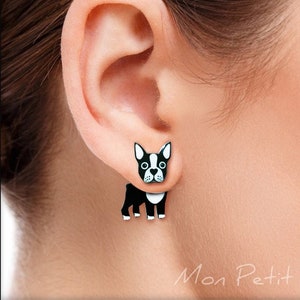Puede incluir: Un par de pendientes de perro Boston Terrier en blanco y negro. Los pendientes están hechos de metal y tienen un diseño 3D.