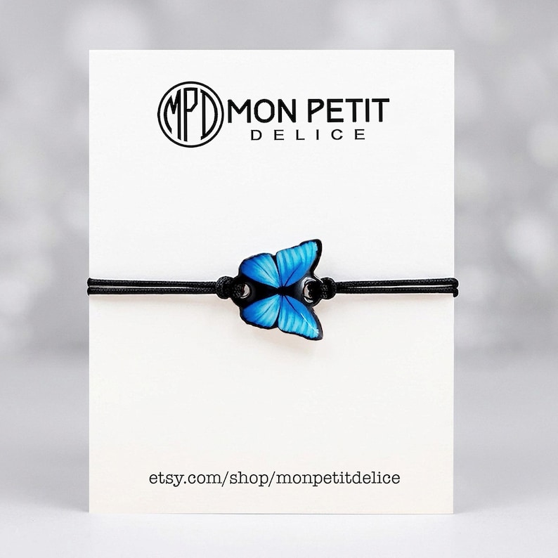 Aesthetic blue Morpho butterfly bracelet made of shrink plastic. Glossy 3D finish with adjustable sliding knot. Meaningful nature-inspired jewelry for best friends, bridesmaids, or daughter gifts. The image shows the bracelet packaged on a card.