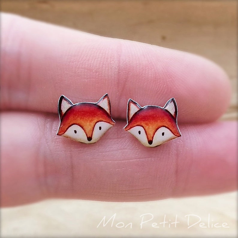 K&ouml;nnte beinhalten: Ein Paar Ohrstecker in Form eines Fuchses. Der Fuchs ist orange und wei&szlig; mit schwarzen Augen und einer schwarzen Nase.