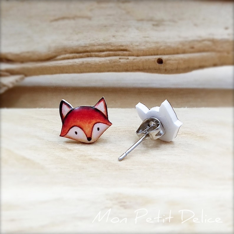 K&ouml;nnte beinhalten: Ein Paar Fuchs-Ohrstecker. Der Fuchs ist orange und wei&szlig; mit schwarzen Augen und einer schwarzen Nase. Die Ohrringe sind aus Polymer Clay gefertigt und haben silberne Ohrstecker.