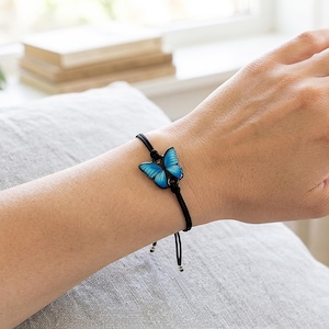Vibrant blue butterfly handmade bracelet with high-gloss finish. Stainless steel hardware on black string. Perfect as a Christmas stocking stuffer, party favor, or anniversary surprise.