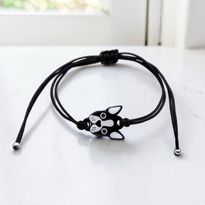 Adjustable black cord bracelet with a Boston Terrier face charm, showing the slide knot closure. Durable and waterproof handmade dog jewelry.