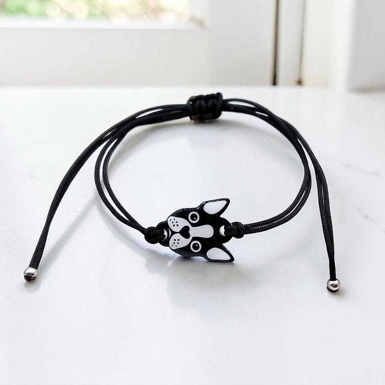 Adjustable black cord bracelet with a Boston Terrier face charm, showing the slide knot closure. Durable and waterproof handmade dog jewelry.