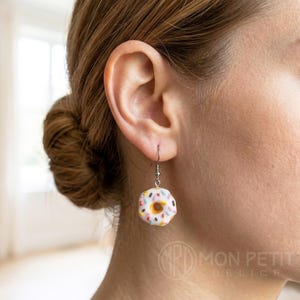 Y2K style white donut earrings worn on ear, handmade jewelry for women and kids.