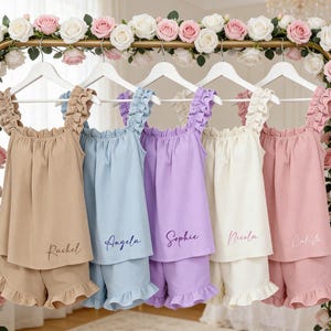 Puede incluir: Una taza de cerámica blanca con un asa negra y el texto "But First, Coffee" en negro, con una fuente de estilo manuscrito. La taza está sobre una superficie blanca.