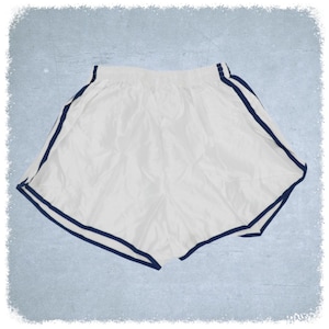 May include: White athletic shorts with navy blue trim around the waistband and leg openings.
