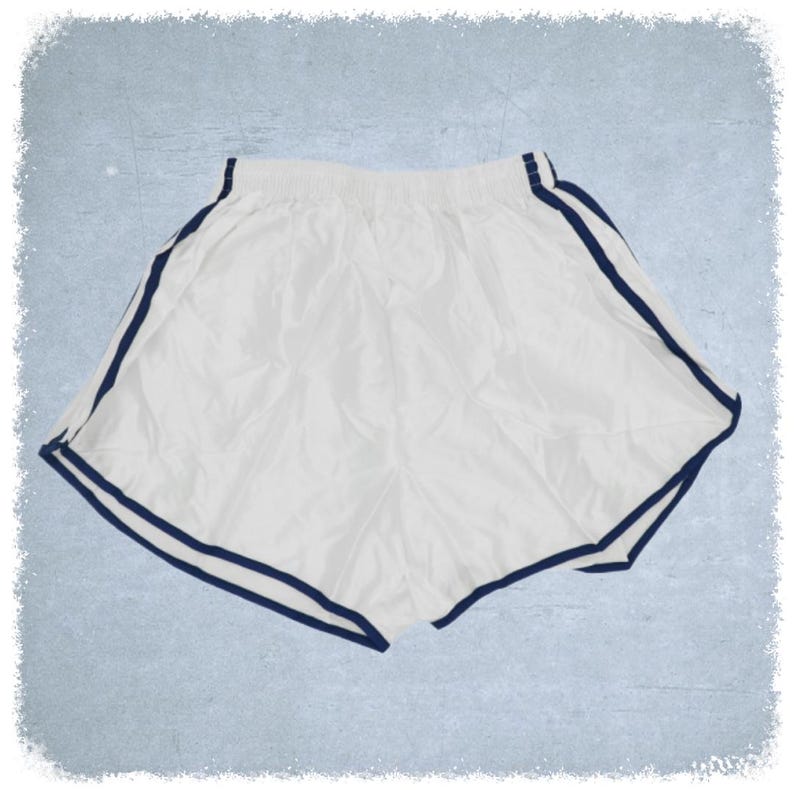 May include: White athletic shorts with navy blue trim around the waistband and leg openings.