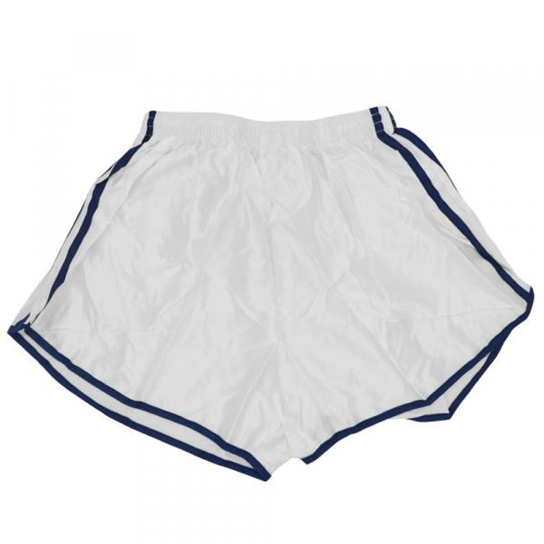 May include: White athletic shorts with navy blue trim around the waist and legs.