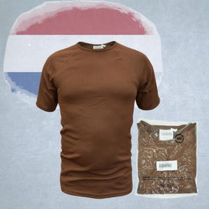 Könnte beinhalten: Ein braunes T-Shirt mit kurzen Ärmeln wird zusammen mit einer verpackten Version gezeigt. Das Shirt hat einen Rundhalsausschnitt und Raglanärmel. Das verpackte Shirt befindet sich in einer transparenten Plastiktüte mit Etiketten. Der Hintergrund zeigt eine niederländische Flagge.