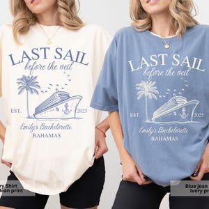 May include: Two t-shirts with a blue jean print of a cruise ship and palm tree with the text "Last Sail Before the Veil" and "Emily's Bachelorette Bahamas" on a white background. One shirt is ivory and the other is blue.