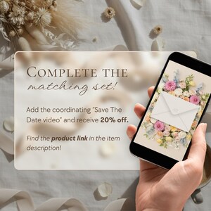 Transparent card on gray fabric with dried flowers reads "Complete the matching set – Save The Date video, 20% off." A hand on the right holds a phone showing the same floral envelope design.