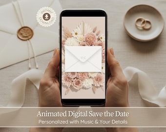 May include: A smartphone displays a digital save-the-date design with a floral arrangement of white and blush roses. An envelope with the initials "VIC" is on the screen. The image includes a wedding invitation, rings, and text.