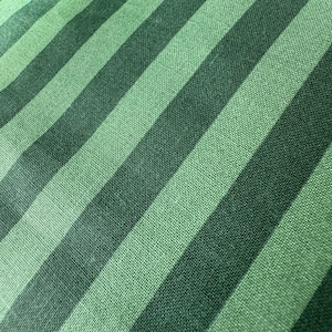 a close-up view of a fabric with diagonal green and black stripes.