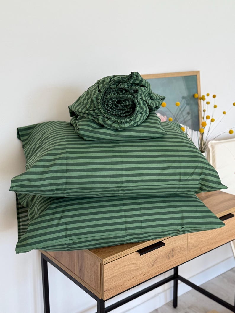 Green striped cotton fitted sheet on bed