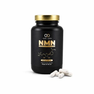 Op de afbeelding: Zwarte fles NMN-capsules met een gouden dop. Het etiket toont de merknaam ABLABS en de tekst "NMN LABORATORY TESTED 99.8% PURITY". De fles vermeldt ook "600mg Capsules" en "Vegan Friendly Capsules MADE IN THE UK". Verschillende witte capsules liggen in de buurt.