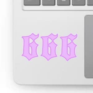 May include: A light purple sticker featuring the number "666" in a gothic font. The sticker is placed on a white laptop, with the keyboard visible in the background.