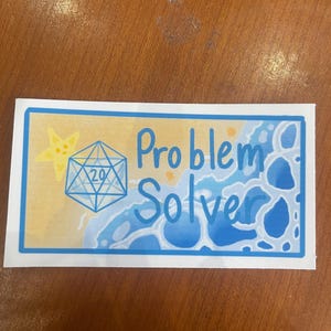 Pode incluir: Um adesivo branco com uma borda azul apresenta um dado azul de 20 faces com uma estrela do mar amarela em um fundo amarelo e azul. O texto "Problem Solver" está escrito em azul.
