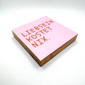 Könnte beinhalten: Eine weiße Keramik-Tasse mit schwarzem Henkel und dem Text "But First, Coffee" in schwarzer, fetter Schrift. Die Tasse steht auf einer weißen Oberfläche.