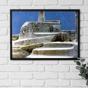 May include: A close-up of a stone structure covered in snow. The structure is made of large, roughly-hewn blocks of stone, and the snow is piled high on top of it. The sky is a bright blue in the background.