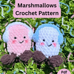 May include: Two crocheted marshmallow-shaped toys, one pink and one blue, with brown feet and smiling faces. The image includes text that reads "Mila and Miles Marshmallows Crochet Pattern" and "Pdf Pattern".