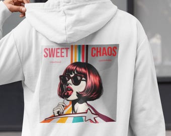 May include: White hoodie featuring a pop art graphic on the back. The graphic includes a woman with red hair and sunglasses, licking a lollipop, with the words "Sweet Chaos" above. The design has a retro, comic book style.