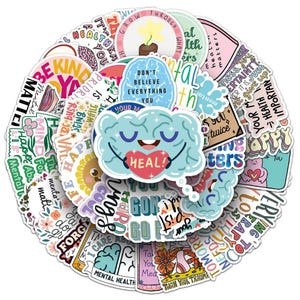Op de afbeelding: Een grote collectie ronde en gestanste vinylstickers met thema's over geestelijke gezondheid, kleurrijke illustraties van hersenen, bloemen en zonnen, met diverse motiverende zinnen zoals "Heal", "Mental Health Matters" en "Don't Believe Everything You Think."
