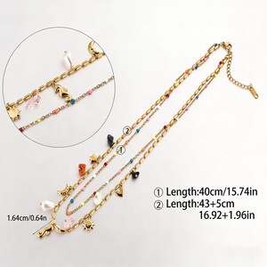May include: Gold-tone layered necklace with colourful beads and charms. The necklace features seahorse, sun, moon, and heart charms. The first layer is 40cm long, and the second layer is 43+5cm long.