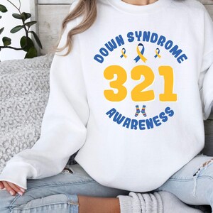 May include: White sweatshirt with blue and yellow text that reads "Down Syndrome Awareness 321".