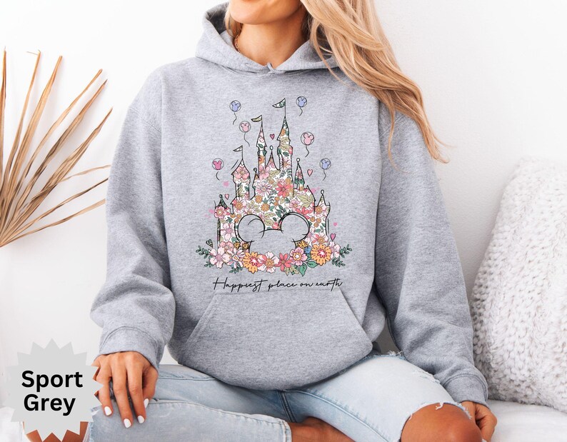 May include: A gray hoodie with a floral design of a castle and the text "Happiest place on earth".