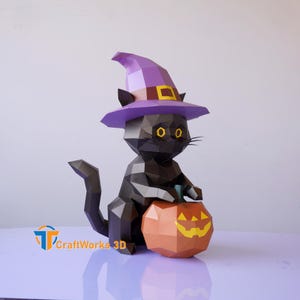May include: A black papercraft cat wearing a purple witch hat with a gold buckle, holding an orange pumpkin with a carved face. The cat has yellow eyes and is a Halloween decoration.