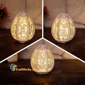 May include: A white egg-shaped paper lamp with intricate cut-out designs of flowers and butterflies. The lamp is illuminated from within, casting a warm glow.