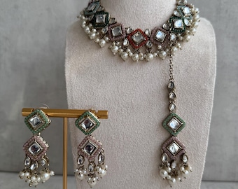 May include: A multi-colored choker necklace with a green, pink, and red design. The necklace is adorned with small, round, white pearls and features a matching set of earrings and a long pendant.