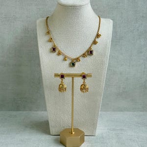 May include: A set of three ceramic mugs with a speckled, matte finish. The mugs are in shades of cream, light gray, and dark gray. Each mug has a simple, minimalist design and a rounded handle.