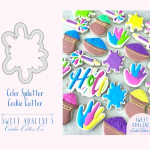 May include: A selection of brightly iced cookies celebrating the Holi festival, featuring handprints, paint splashes, and bowls. The word "Holi" is written in colourful icing. A cookie cutter shaped like a colour splatter is also shown.