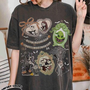 Puede incluir: Camiseta gris oscuro con personajes de "Pesadilla antes de Navidad". El dise&ntilde;o incluye a Jack Skellington, Sally, Oogie Boogie y Zero, con el texto "The Nightmare Before Christmas."