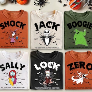 May include: Six t-shirts with crew necks featuring characters from "The Nightmare Before Christmas." The shirts are in various colors: orange, cream, and green. Each shirt has a character's name in large black letters, with graphics and the text "EST. 1993."