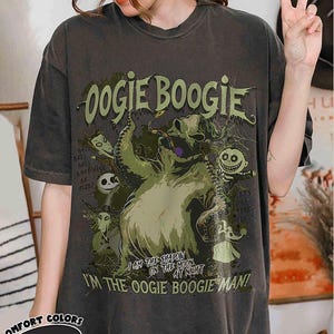Puede incluir: Camiseta gris oscuro con la inscripci&oacute;n "Oogie Boogie" en verde y un dibujo del personaje de The Nightmare Before Christmas. La camiseta tambi&eacute;n incluye las frases "I am the shapon on the moon at night" y "I'm the Oogie Boogie Man!"