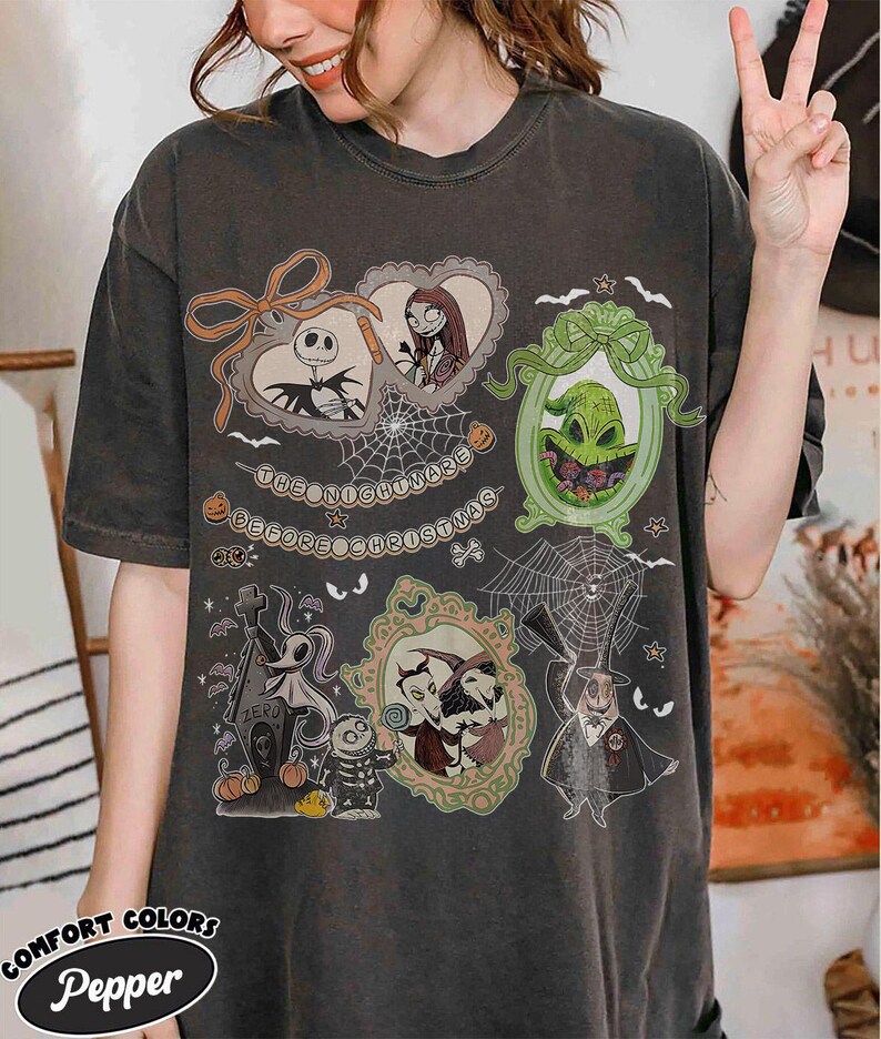 Puede incluir: Camiseta gris oscuro con personajes de "Pesadilla antes de Navidad". El dise&ntilde;o incluye a Jack Skellington, Sally, Oogie Boogie y Zero, con el texto "The Nightmare Before Christmas."