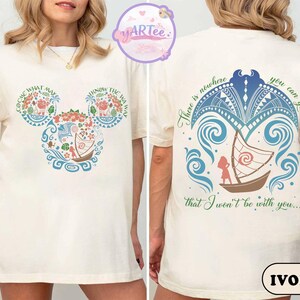 May include: Ivory-colored t-shirt featuring a colorful design inspired by a popular animated film. The front displays a Mickey Mouse-shaped design with floral and boat motifs, and text. The back features a boat scene with text. The shirt is a casual wear item.