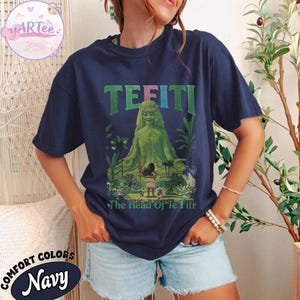 K&ouml;nnte beinhalten: Marineblaues T-Shirt mit einer gr&uuml;nen Illustration von Te Fiti aus dem Film Vaiana, mit dem Text "TE FITI" &uuml;ber dem Bild und "The Head Of Te Fiti" darunter. Das Shirt ist von der Marke Comfort Colors.