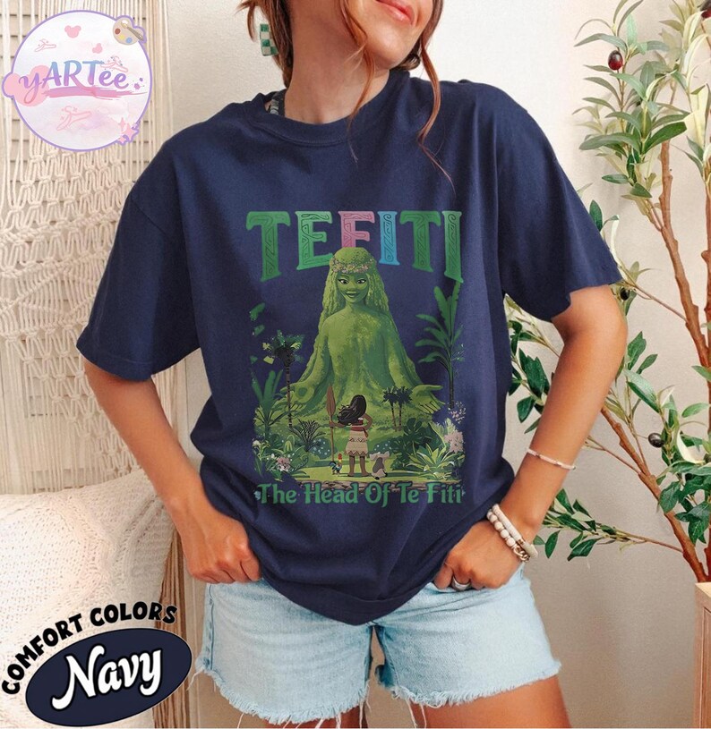 K&ouml;nnte beinhalten: Marineblaues T-Shirt mit einer gr&uuml;nen Illustration von Te Fiti aus dem Film Vaiana, mit dem Text "TE FITI" &uuml;ber dem Bild und "The Head Of Te Fiti" darunter. Das Shirt ist von der Marke Comfort Colors.