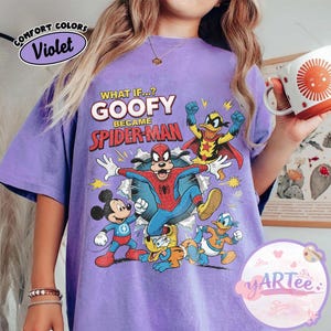 May include: A lilac-coloured t-shirt with a graphic of Goofy as Spider-Man and other Disney characters. The text "WHAT IF...? GOOFY BECAME SPIDER-MAN" is printed above the characters. The shirt has a vintage, distressed appearance.